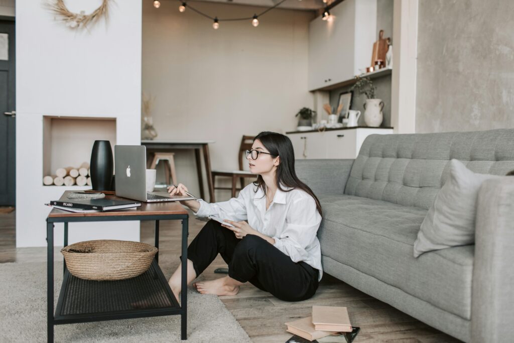 Woman working a laptop while sitting on the floor